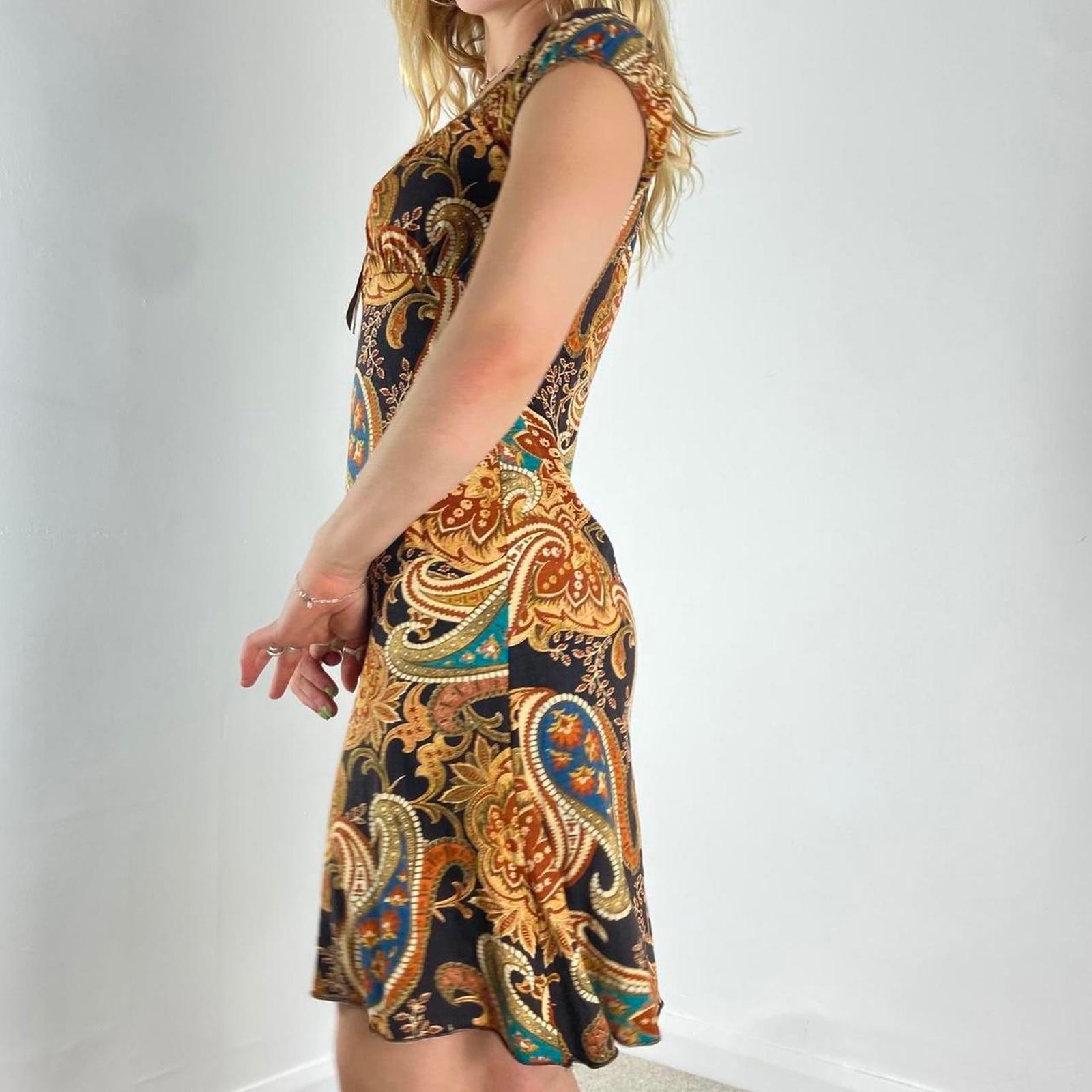 Beautiful black dress with orange,yellow and green graphic paisley patterning and a milkmaid cut- ties with a little bow