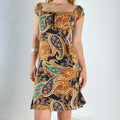 Beautiful black dress with orange,yellow and green graphic paisley patterning and a milkmaid cut- ties with a little bow