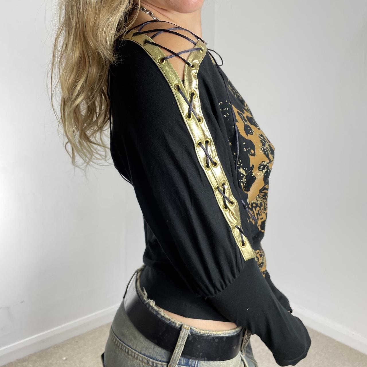 Off-the-shoulder gold and black graphic batwing top
